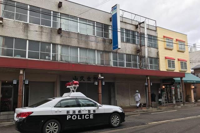 建物の看板が強風で壊れそうになって一ノ木戸商店街は一時的に通行止め。蒼い看板の右の金属製の広告の枠が壊れそうになった