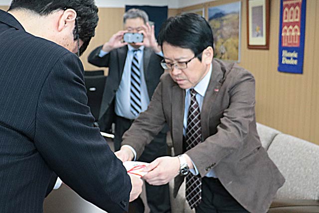 鈴木市長に寄付を手渡すサーモス新潟事業所の山田事業所長