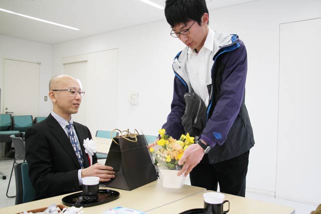 中村さんにフラワーアレンジメントを贈る長男亮さん