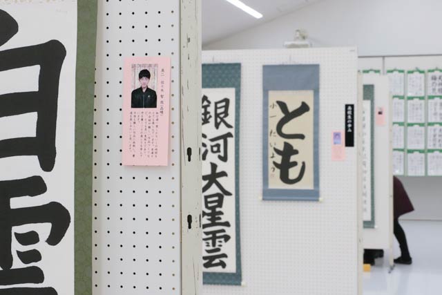 文科省後援の毛筆書写技能検定試験合格作品には顔写真付きのプロフィルも添えて展示