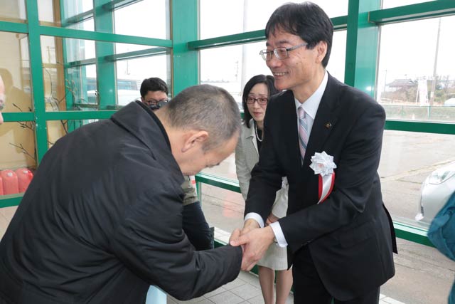 握手して支持者らを送る鈴木氏