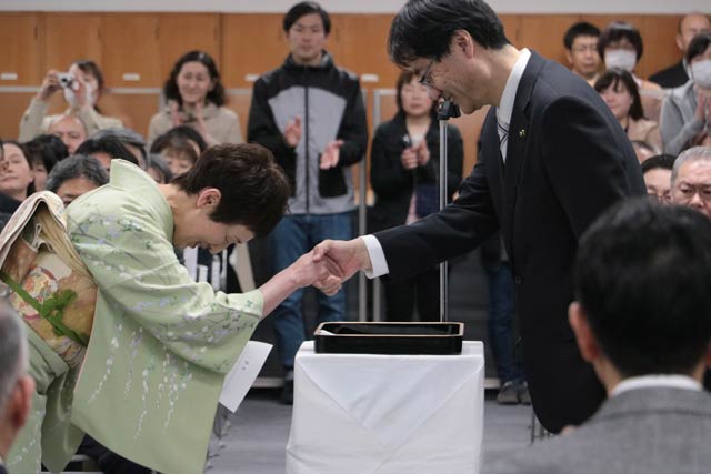 退職者に辞令書を渡して握手する鈴木市長