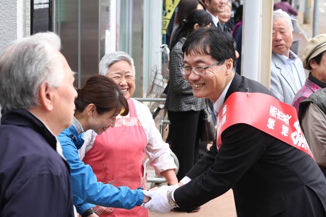 1日限りの選挙戦で戸隠神社前で街宣を行ったあと集まった支持者一人ひとりと握手する鈴木氏