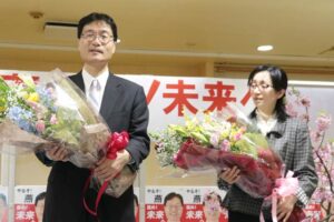 当選が決まって花束を受ける鈴木氏と妻昭子さん