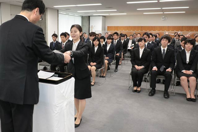 鈴木市長から新採用職員一人ひとりに辞令書を手渡す