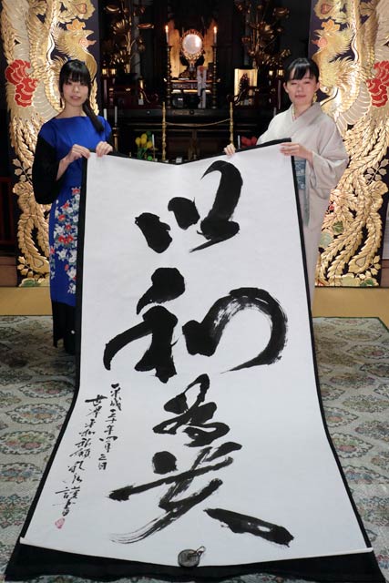 奉納揮毫した「以和為貴」と書の下田さんと篠笛の熊倉さん