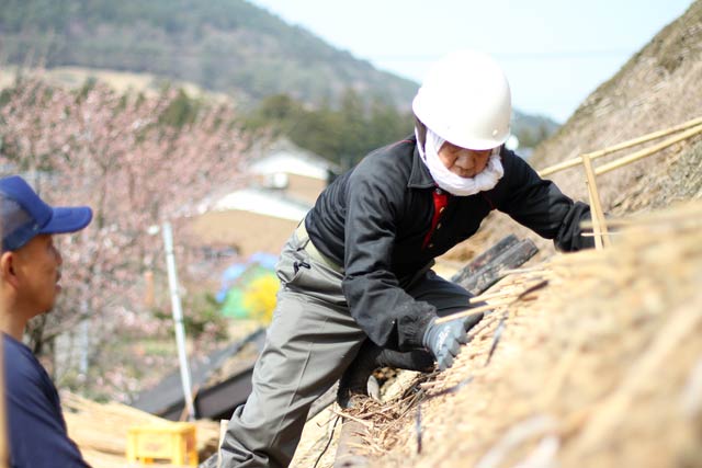 茅葺職人として新潟県文化財保護条例に基づく認定技術職人でもある金子彦治さんが修復作業の親方