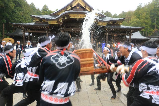 神湯を載せたみこしを神社拝殿前で激しくもむ