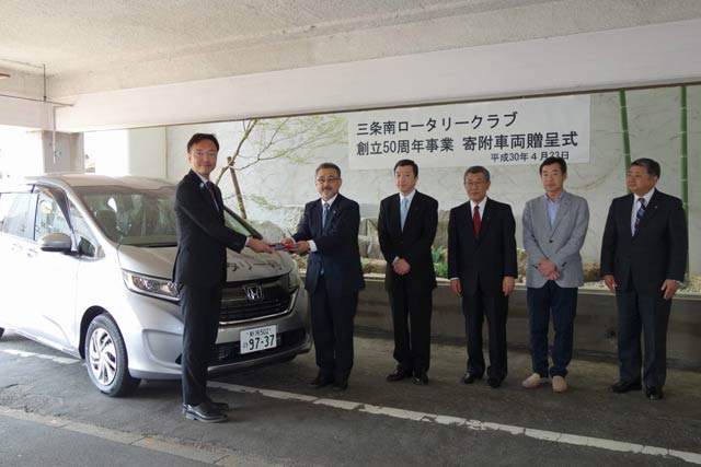 三条南ロータリークラブの野崎会長から国定市長に寄付した車両1台の目録を手渡す
