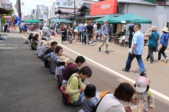 歩道に腰掛けて「いただきます」