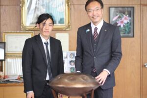 三条市の地域おこし協力隊に着任したハンドパン奏者の久保田亮平さん(左)と国定市長