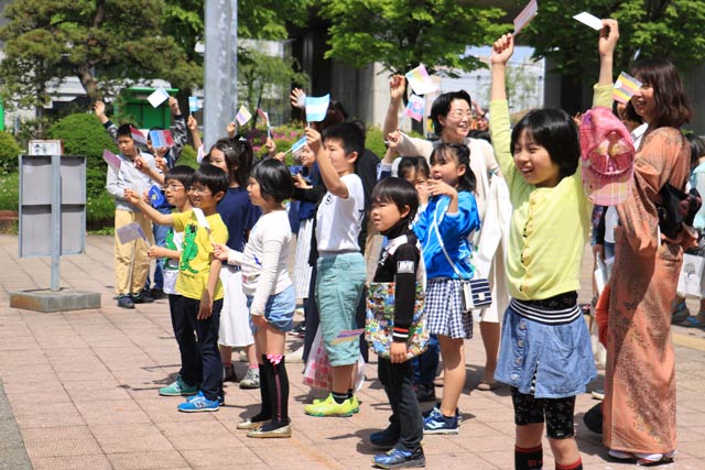 外交団のバスを手を振って見送る
