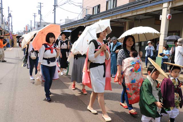 赤ちゃんを抱っこして歩くお母さん