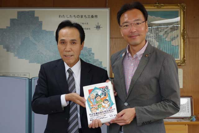 コミック誌『時をまう六角』と明間印刷所の明間社長(左)と国定市長