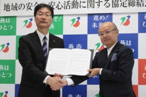 協定書を交わして握手する鈴木市長(左)と三原社長