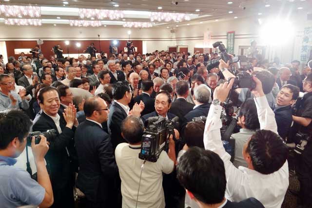 入場する花角氏を報道関係者が囲む