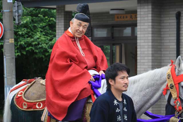 ウマに乗って進む小池宮司