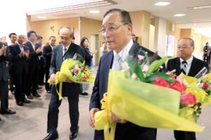 花束を手に職員の拍手に送られる三役