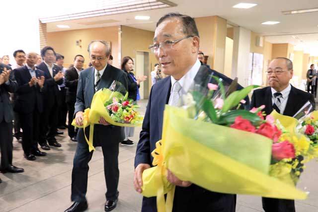 花束を手に職員の拍手に送られる三役