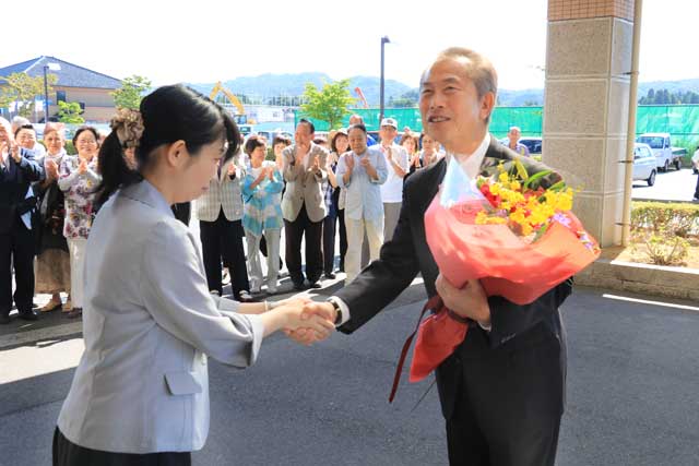 初登庁した佐野町長に職員から花束を渡す