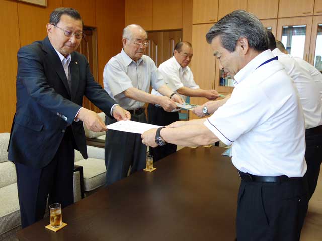 三条市交通安全協会が夏季の児童の交通事故防止を図ろうとカエルの夜行反射材と児童向けの交通安全教育資料を三条市教育委員会に寄付