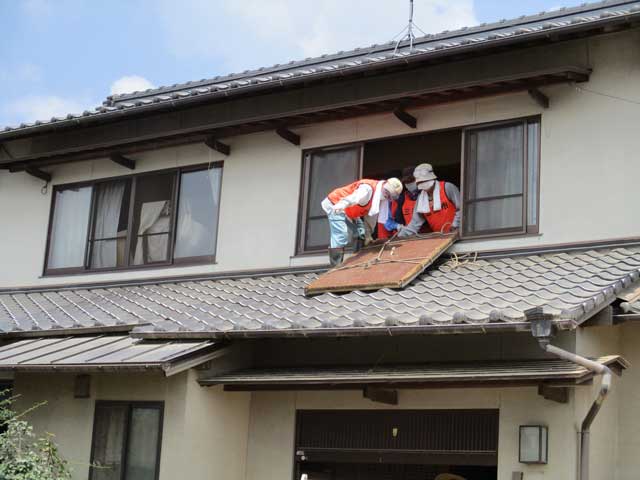 2階から畳を運び出すボランティア