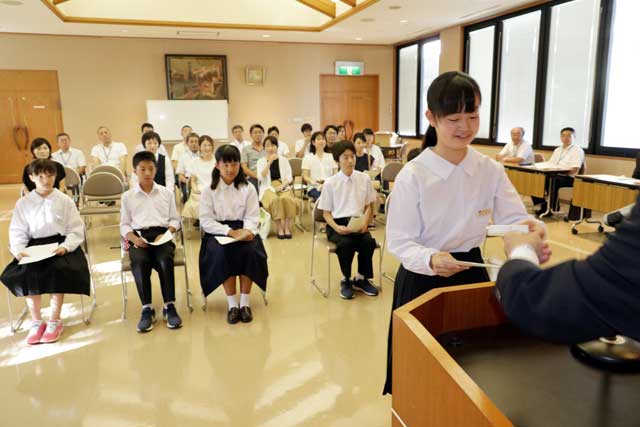 結団式で小林村長からエルデネ村へ派遣する中学生6人に任命書とモンゴル語の名刺100枚を手渡す