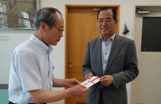外山社長(右)から三条市社協の渡辺事務局長に寄付を手渡す