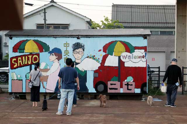 イヌの散歩で通りかかった人が足を止めて作品を話のネタに