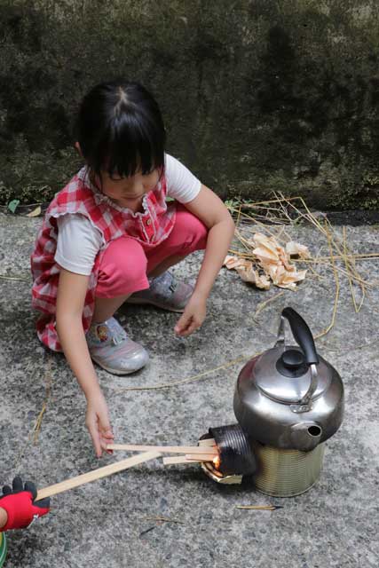 まきをくべて使い方を実践する子どもたち