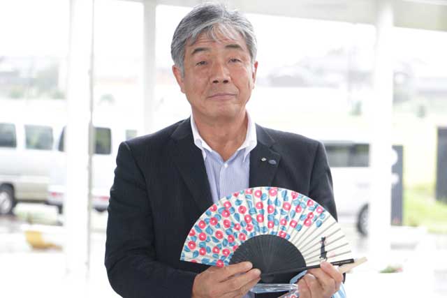 越佐観光タクシーの佐藤代表取締役とスワロー号利用者にプレゼントした扇子