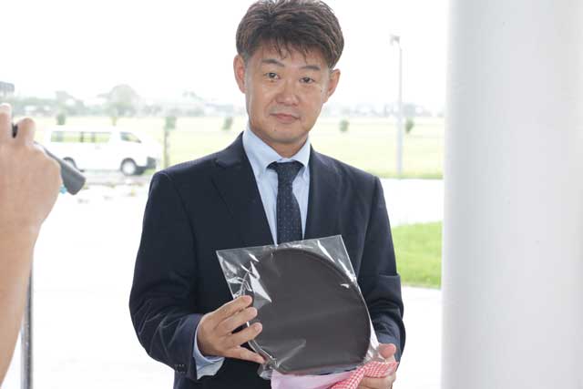 燕タクシーの竹内代表取締役社長とおでかけきららん号の利用者にプレゼントした半月盆