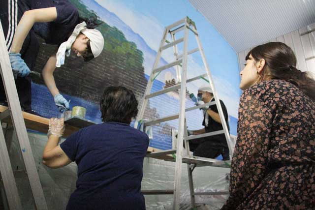 東京銭湯大使のステファニーさん(右)も見守るなかで丸山さん、弟子の勝美さん、妻の千代美さんで協力して制作