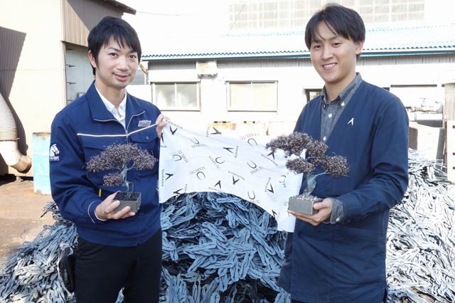 幹となる廃材の前でマルト長谷川工作所(左)と諏訪田製作所の担当者