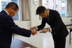 高野選挙管理委員長から当選証書を受ける国定市長