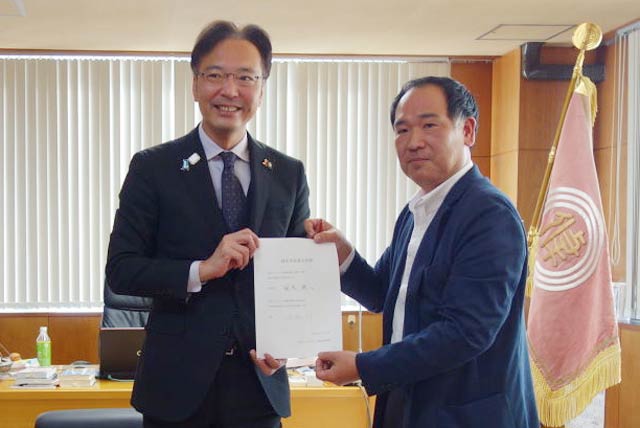 名誉会長就任に調印した国定市長(左)と中条会長