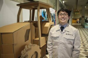燕三条じばさん年末フェアの会場で「下町ロケット」の佃製作所のユニホームを着て段ボールトラクターの座席に座ることができる