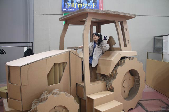 「下町ロケット」に登場する佃製作所のユニホームを着て原寸大の段ボールトラクターに試乗できる