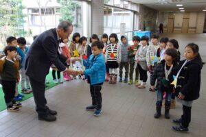 三条市社会福祉協議会の渡辺事務局長に募金で集めた7千円余りを手渡す三条市立嵐南保育所の年長児