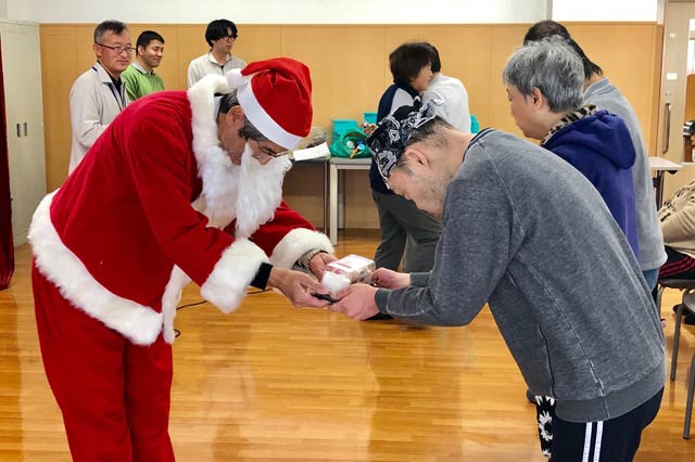利用者にショートケーキを手渡す藤本課長