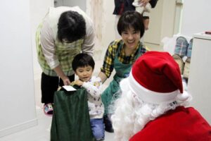 分水商工会青年部がサンタクロースにふんし保護者に代わってクリスマスプレゼントを届ける