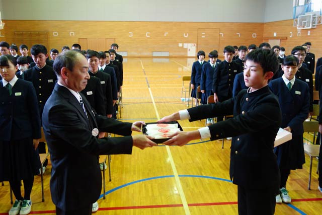三条市立第四中学校でJAにいがた南蒲の高山専務理事から3年生代表に「難関突破米」を手渡す
