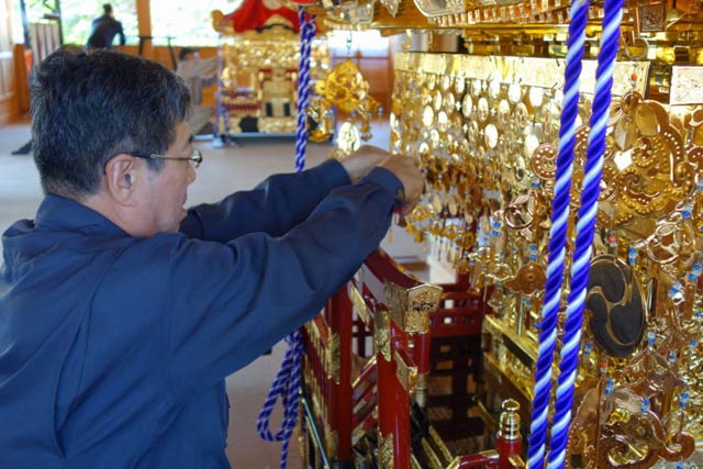 八幡宮拝殿でみこしを組み立てる近藤建築の近藤さん