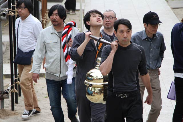 参道を抜けて八幡宮へ拝殿へ鈴を担いで運ぶ