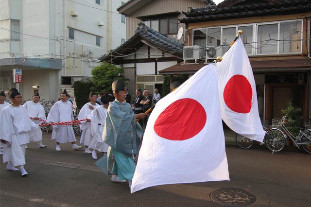 新天皇即位を祝って日の丸を掲げた御輿行列