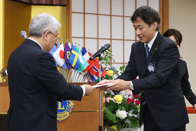 高取会長から安中教育長に記念事業の目録を手渡す