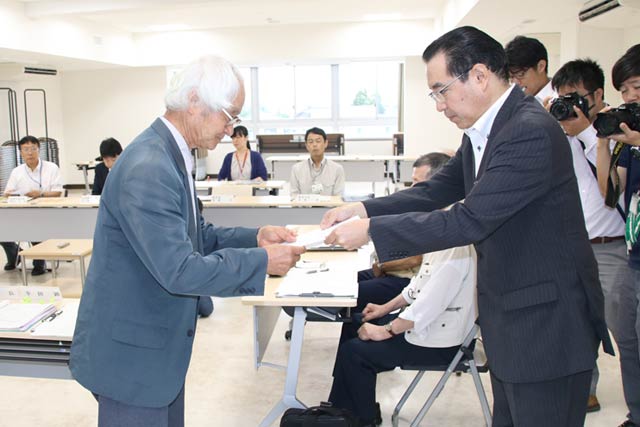遠藤教育長(右)から幸田燕市文化財調査審議会委員長に国上寺本堂の現状変更についての諮問書を手渡す