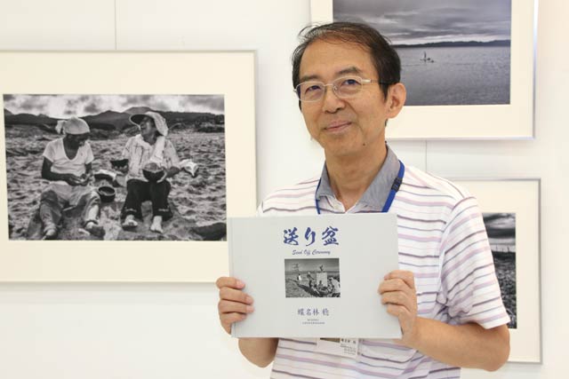 会場で展示作品をすべて収録した写真集を手に蝶名林さん