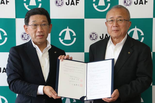観光協定書を手にJAF新潟支部の遠藤佳彦支部長(左)と小林豊彦村長