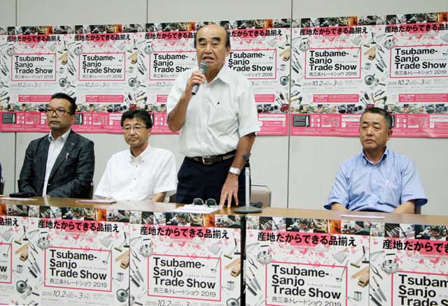記者会見であいさつする実行委員長の田野燕商工会議所会頭